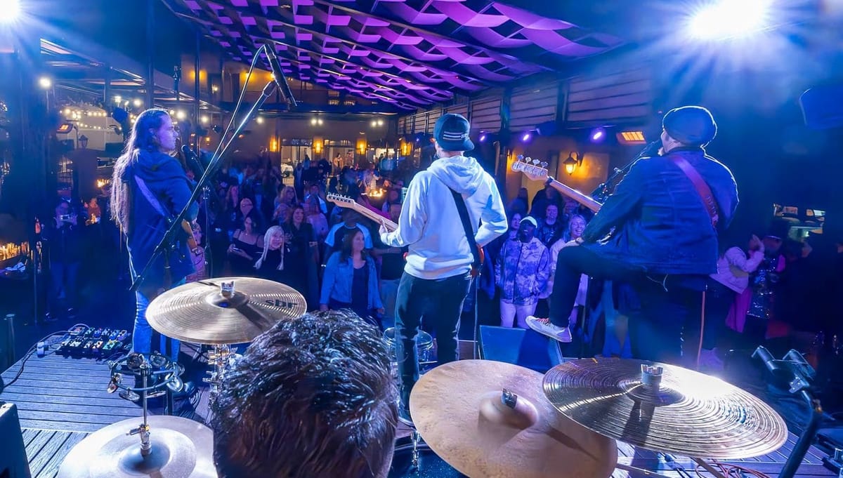 Band performing for a crowd under blue and purple stage lights at Baily’s in Old Town Temecula